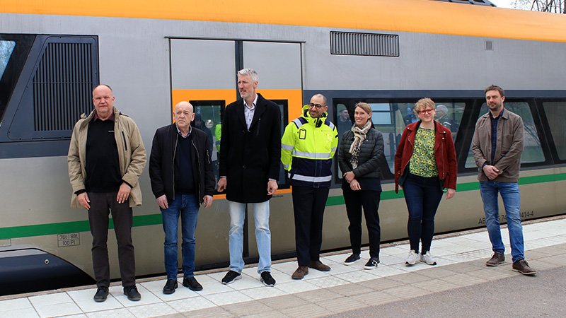 Representanter från Torsby kommun, Region Värmland, Trafikverket och Sunne kommun står på perrongen vid Torsby station framför ett Värmlandstrafiktåg.