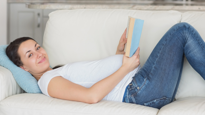 gravid kvinna läser i soffan