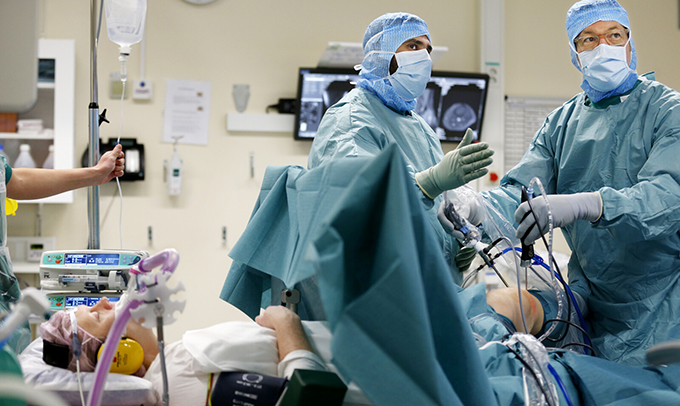 Operationssal med två kirurger som arbetar med en patient.