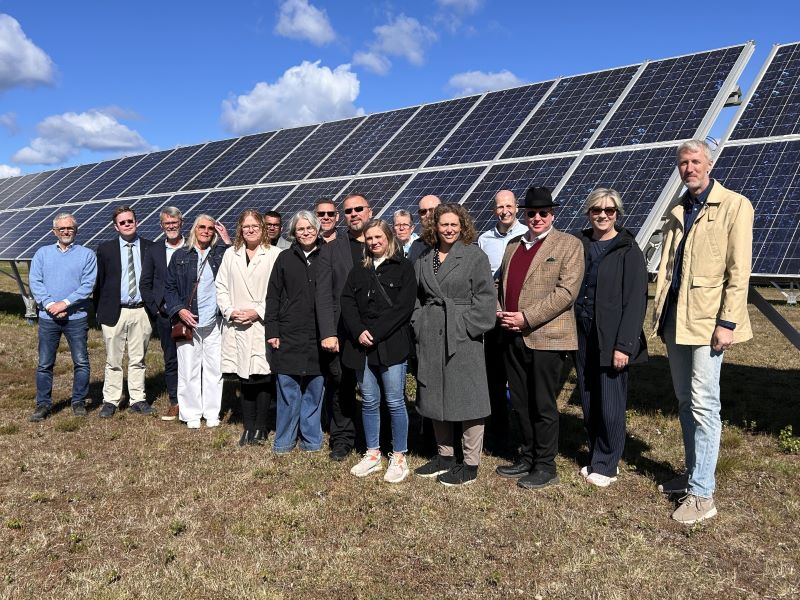 En gruppbild där nämnden står framför solceller.