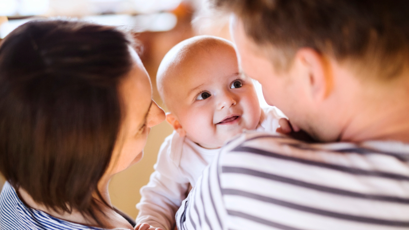 bebis som tittar på förälder och ler