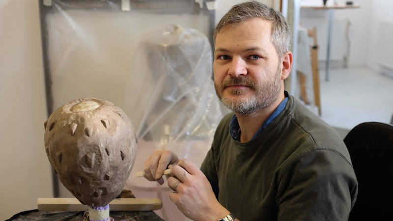 Man arbetar med skulptur.