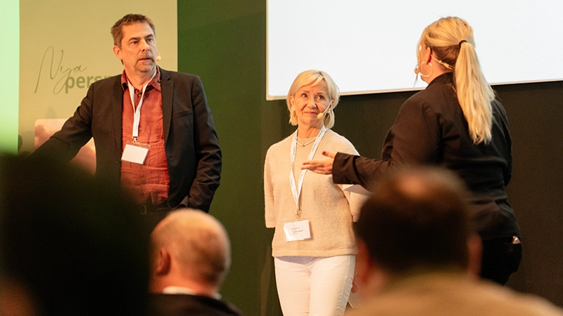 En man och två kvinnor samtalar på en scen.