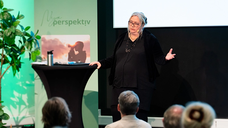 Kvinna pratar på en scen.