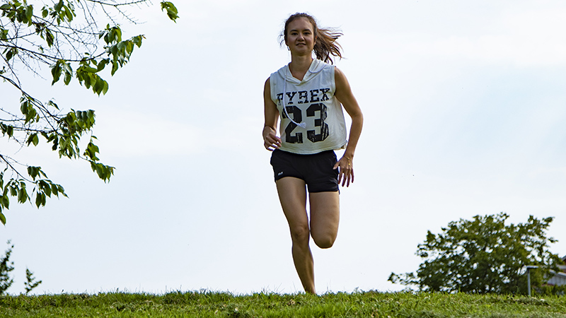 Kvinna springer på gräs.