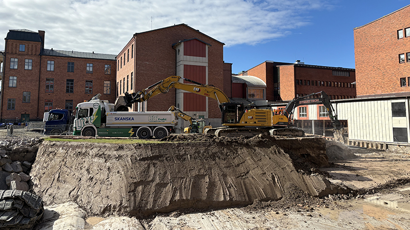 Grävmaskin fyller en ellastbil.