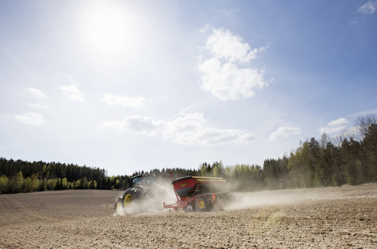 En traktor som kör över en lerig åker.