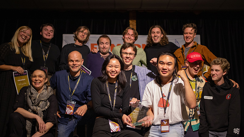 Gruppbild på vinnarna och juryn poserar framför kameran. 