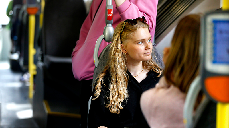 Kvinna och flera resenärer ombord på buss