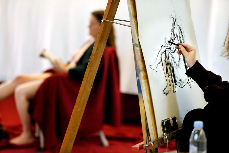 Krokimålning i förgrunden med modellen i bakgrunden