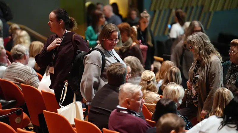 Publiken sätter sig på plats.