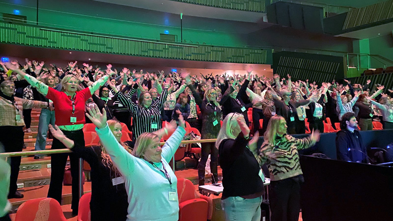 Publik sträcker upp händerna i luften.