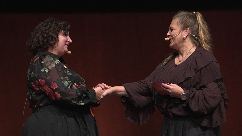 Två kvinnor gör en handhälsning.