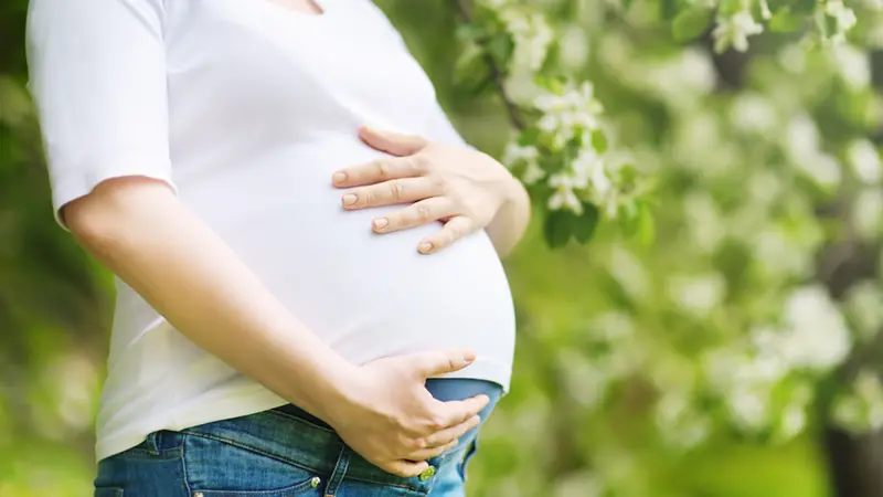 närbild på en gravid kvinnas mage