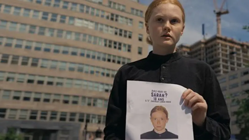 Flicka håller i ett papper.