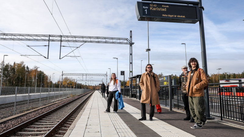 Personer står och väntar på tåg