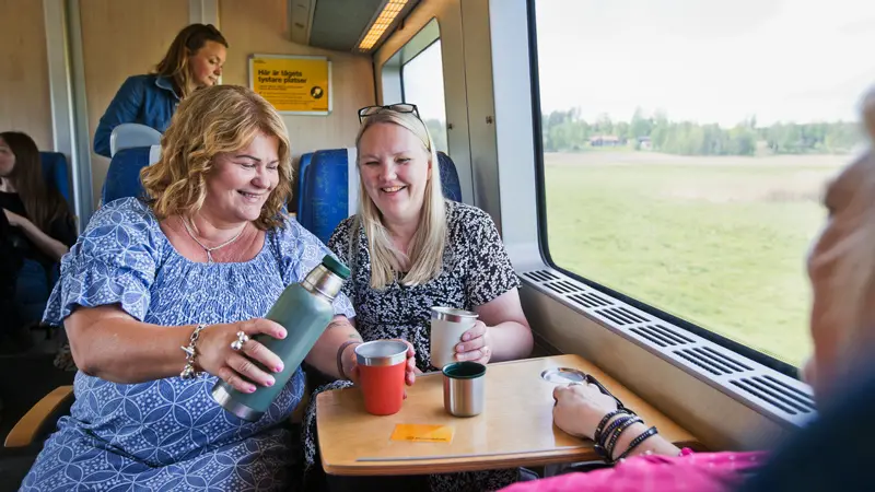 Kvinnor dricker kaffe ombord på ett av Värmlandstrafiks tåg.