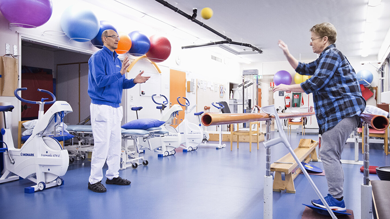 Fysioterapeut kastar boll med en patient.