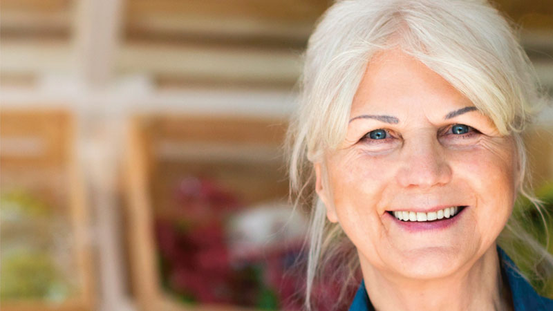 Leende gråhårig kvinna.