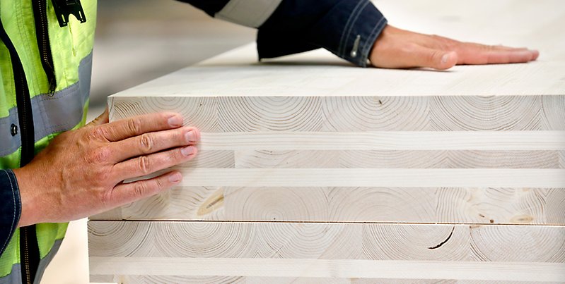 Händer på trämaterial.