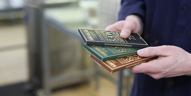 Chokladförpackningar i händerna på person.