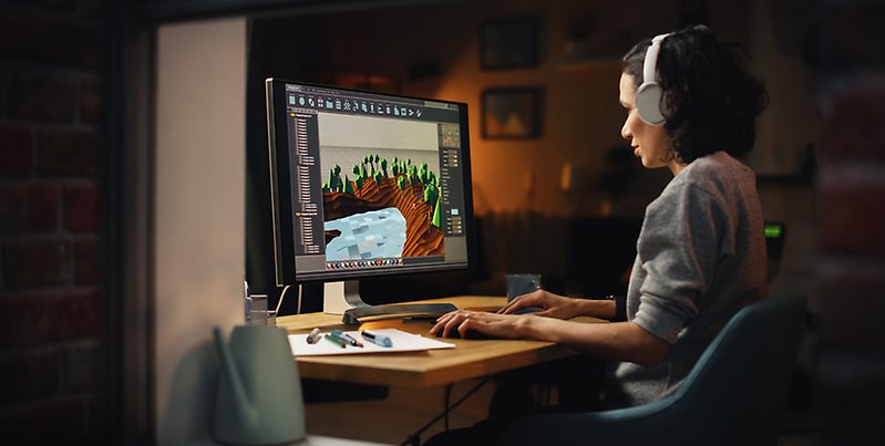 Kvinnlig spelutvecklare vid dator.