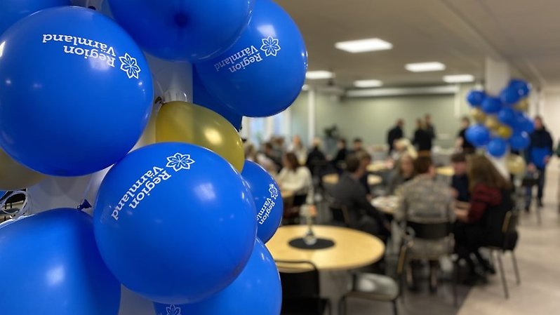 Ballonger i förgrunden och människor som sitter och äter i bakgrunden