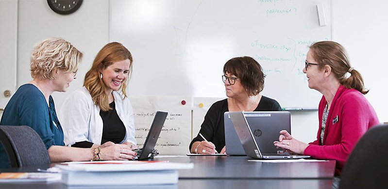 Fyra kvinnor runt ett bord har möte