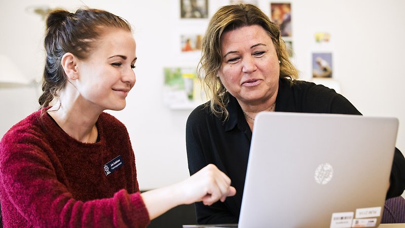 Två personal tittar tillsammans på en dator.