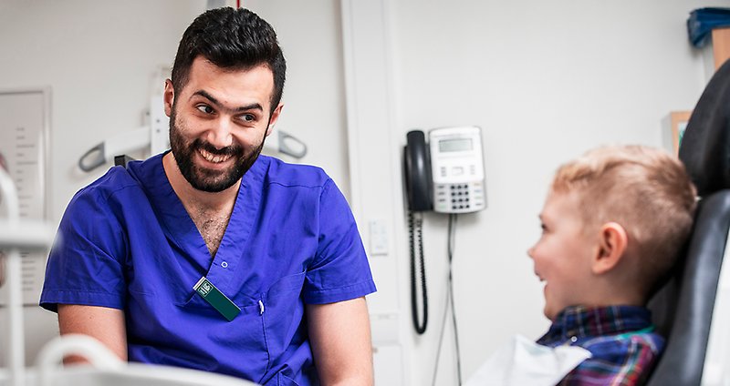tandläkare pratar med barnpatient